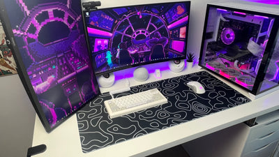 Black topography gaming mousepad sitting on a desk in a gaminh setup