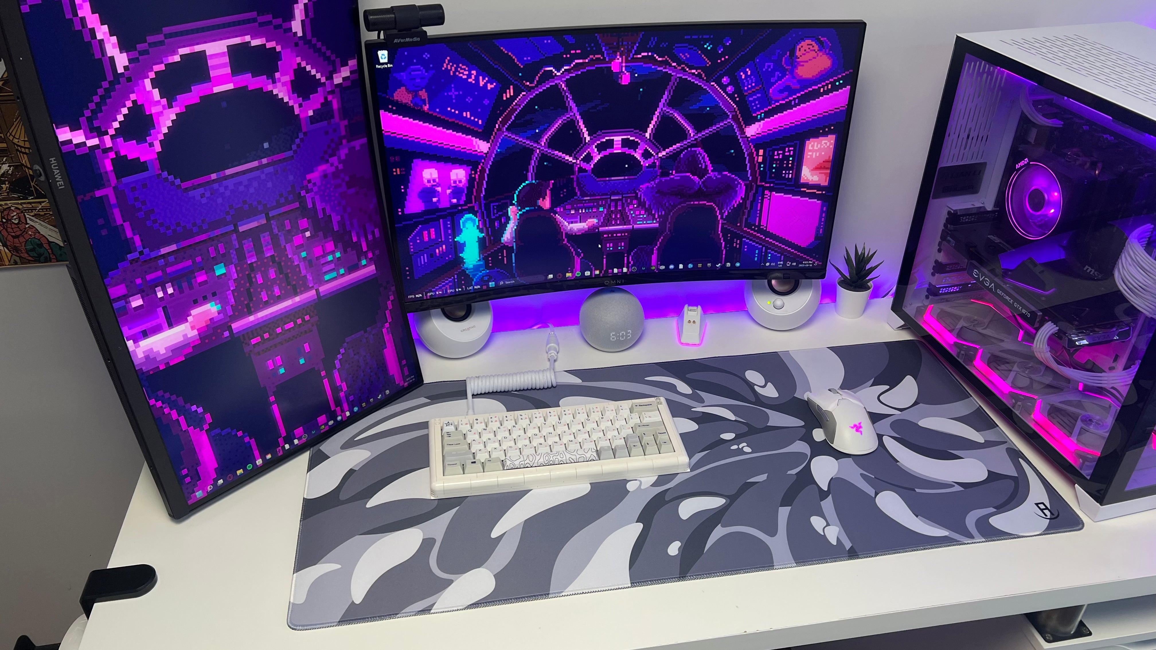 Computer setup with multiple monitors on a desk and front view of gaming setup with black and white liquefied V2 desk pad with gaming keyboard and gaming mouse on mousepad