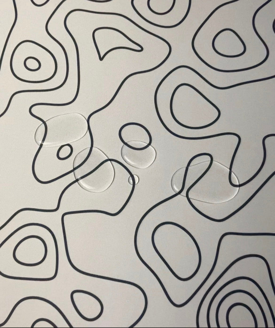 azurepads white topography desk pad with water on it showing the water proof feature
